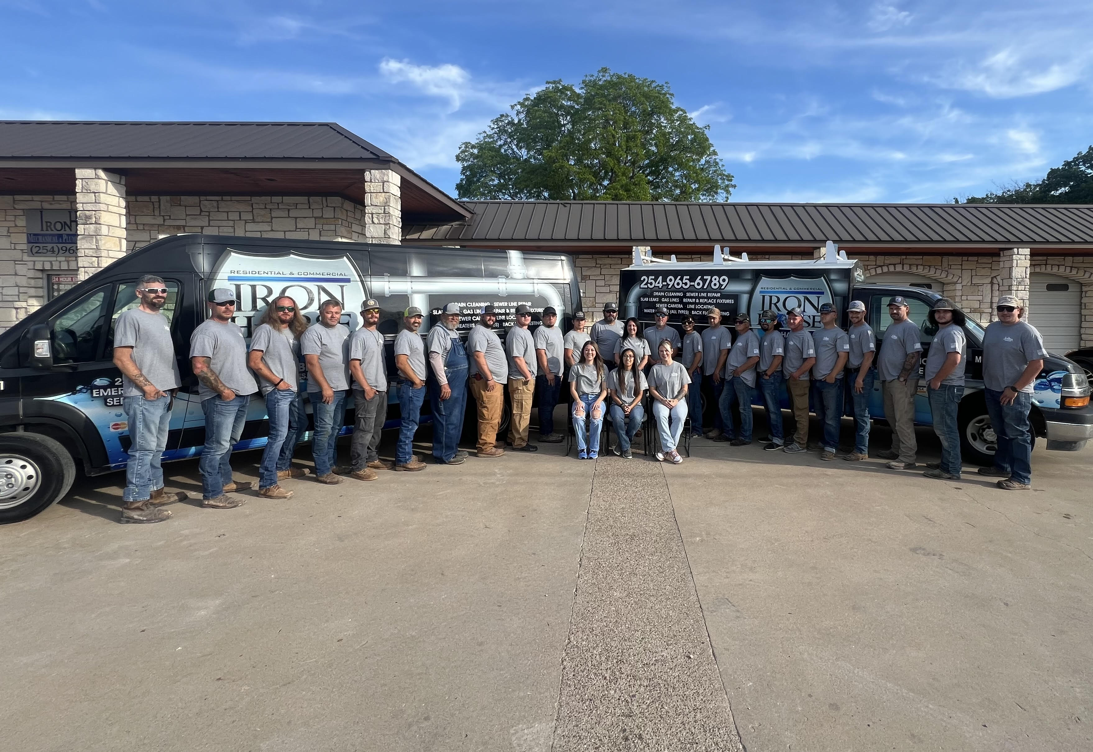 The Iron Horse Mechanical & Plumbing Services team of licensed plumbers standing in front of their service vans at the Stephenville, TX office